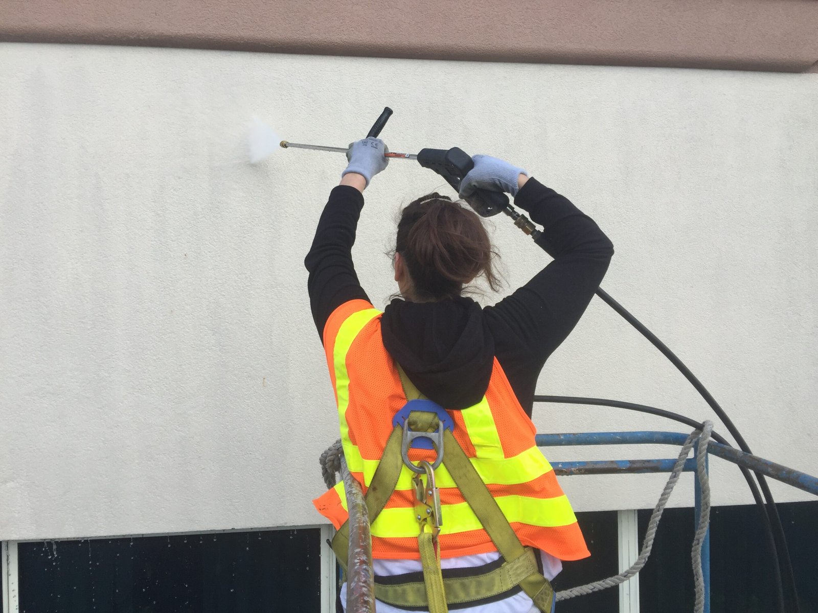 Woman commercial painter working safely at height